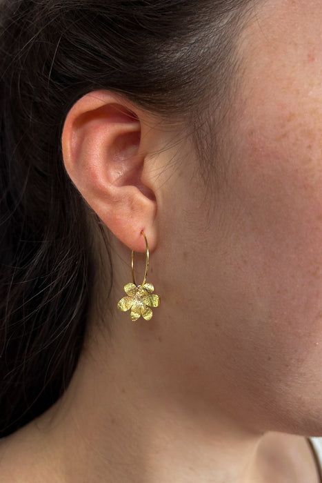 Zart und verspielt – die „Mini Jacintos“ sind handgefertigte Ohrringe mit einer einzelnen, fein ziselierten Blüte, die sanft an einer Creole schwingt. Ihre schlichte Eleganz macht sie zu einem dezenten, aber besonderen Begleiter für jeden Tag.