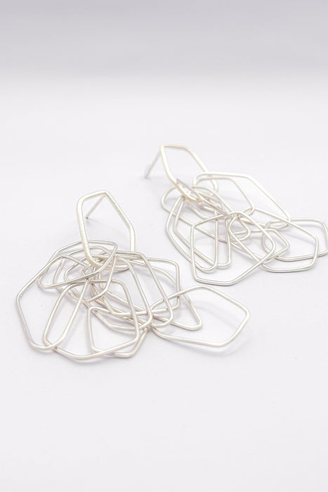 Leicht, verspielt und voller Bewegung – die Ohrringe „Fadenspiel“ verbinden zarte Linien zu einem kunstvollen Ganzen. Feine, unregelmäßig geformte Elemente hängen in fließender Bewegung zusammen und erzeugen beim Tragen ein lebendiges Spiel von Licht und Form.