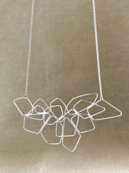 Das Collier „Fadenspiel“ ist ein elegantes Zusammenspiel aus ineinander fließenden Linien – zart, beweglich und doch kraftvoll in seiner Form. Jedes einzelne Element wird von Hand gebogen und zu einem harmonischen Gesamtbild verbunden.