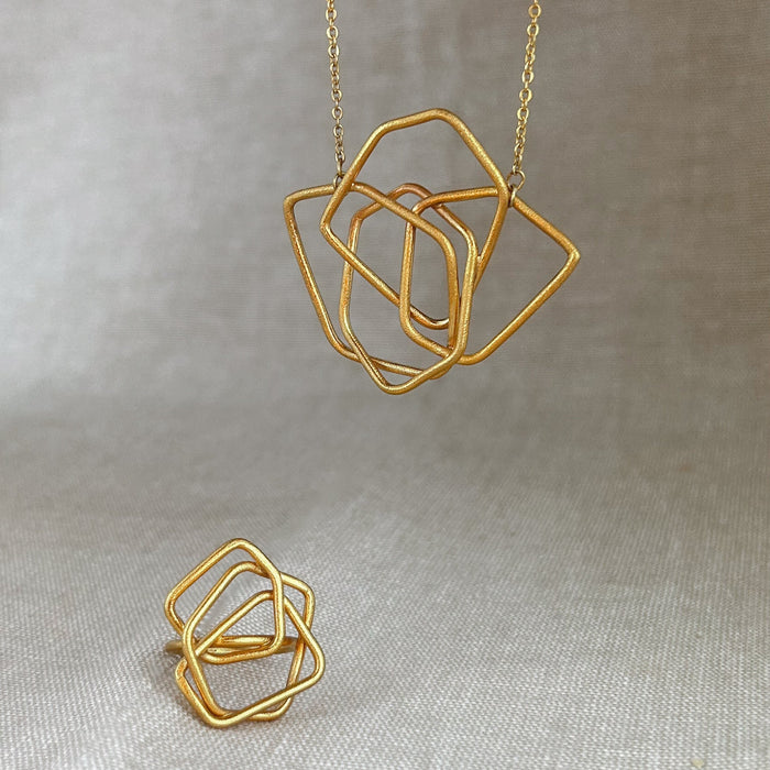 Das Collier Triade“ vereint unregelmäßig geformte, ineinander verschlungene Elemente zu einem harmonischen Mittelpunkt. Die klaren Linien und die sanft matte Oberfläche verleihen dem Schmuckstück eine ruhige, zugleich kraftvolle Ausstrahlung. Mit Ring Aus der gleiche Collexion 