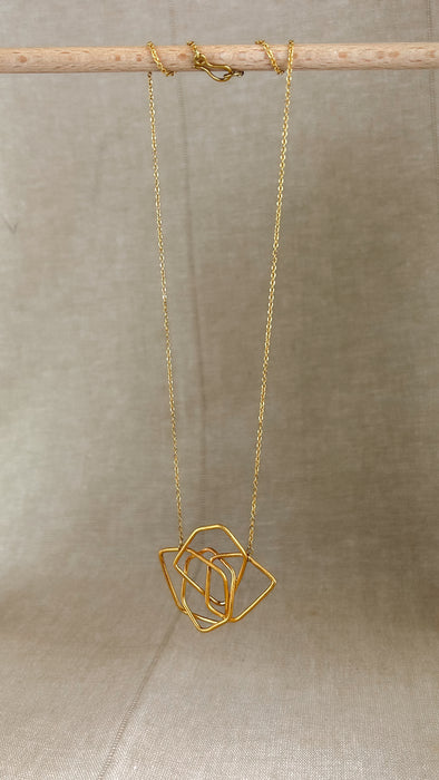 Das Collier Triade“ vereint unregelmäßig geformte, ineinander verschlungene Elemente zu einem harmonischen Mittelpunkt. Die klaren Linien und die sanft matte Oberfläche verleihen dem Schmuckstück eine ruhige, zugleich kraftvolle Ausstrahlung.