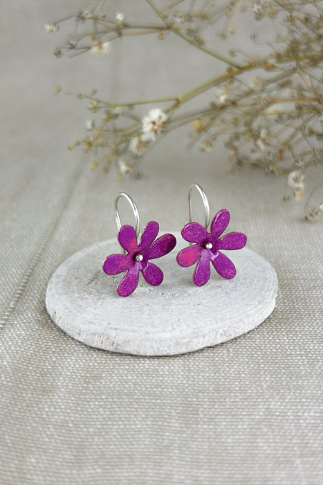 Die „Silvestres“ sind leichte, handgefertigte Ohrringe mit einer zarten Blüte, die dezent schwingt und jedem Look eine natürliche, frische Note verleiht. Die Blume wird aus Silber oder Messing gefertigt und emailliert, sodass verschiedene Farbvarianten möglich sind. Die Ohrhaken bestehen immer aus 925er Silber – angenehm zu tragen und hochwertig verarbeitet, ganz in traditioneller Handarbeit.