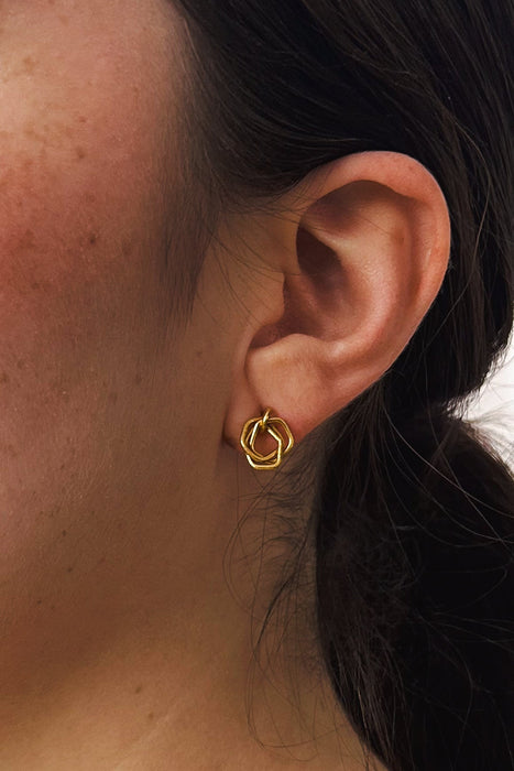 Zeitlos modern und doch handwerklich geprägt – diese geometrischen Ohrringe vereinen klare Linien mit warmer, goldener Ausstrahlung. Die ineinander verschlungenen Formen erzeugen Bewegung und Tiefe, während die matte Oberfläche einen sanften Glanz verleiht.