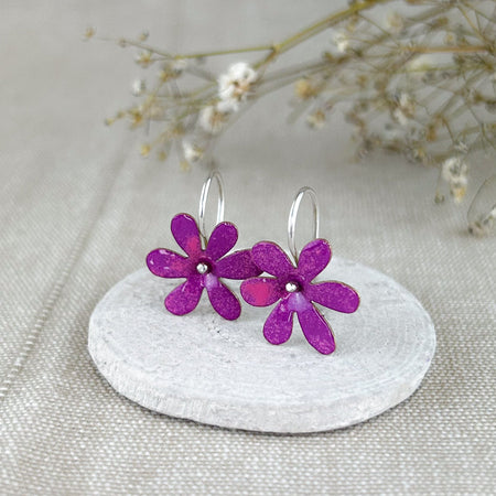 Die „Silvestres“ sind leichte, handgefertigte Ohrringe mit einer zarten Blüte, die dezent schwingt und jedem Look eine natürliche, frische Note verleiht. Die Blume wird aus Silber oder Messing gefertigt und emailliert, sodass verschiedene Farbvarianten möglich sind. Die Ohrhaken bestehen immer aus 925er Silber – angenehm zu tragen und hochwertig verarbeitet, ganz in traditioneller Handarbeit.