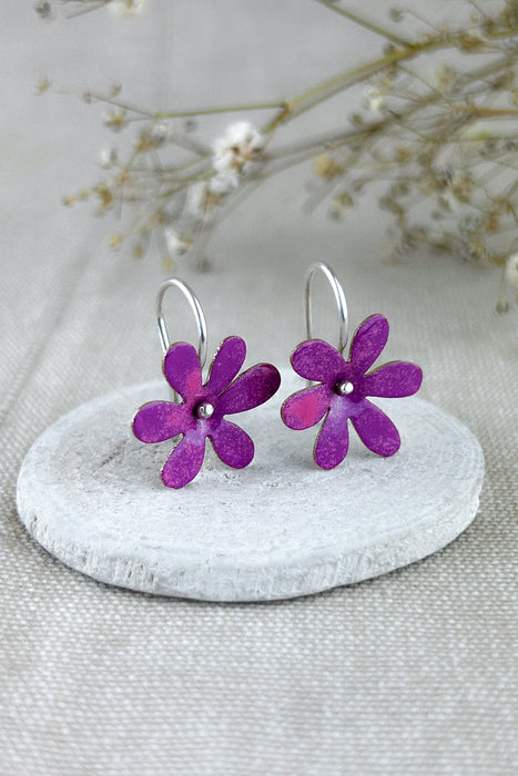 Die „Silvestres“ sind leichte, handgefertigte Ohrringe mit einer zarten Blüte, die dezent schwingt und jedem Look eine natürliche, frische Note verleiht. Die Blume wird aus Silber oder Messing gefertigt und emailliert, sodass verschiedene Farbvarianten möglich sind. Die Ohrhaken bestehen immer aus 925er Silber – angenehm zu tragen und hochwertig verarbeitet, ganz in traditioneller Handarbeit.