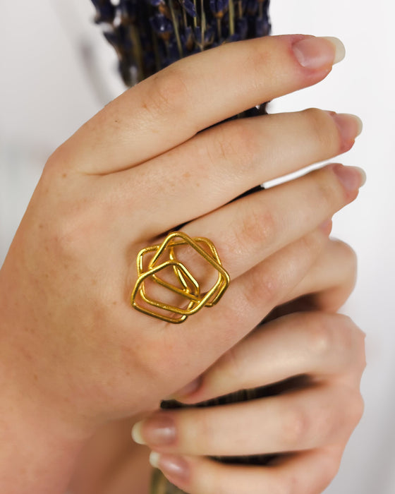 Ein moderner Ring mit klarer, architektonischer Formensprache. Handgefertigt aus feinem 100% recyceltem Sterlingsilber 925, besticht dieses Schmuckstück durch seine leichte, offene Struktur aus ineinander verschlungenen Quadraten. Die matte Oberfläche verleiht dem Ring eine sanfte, elegante Ausstrahlung – zeitlos und doch auffällig.