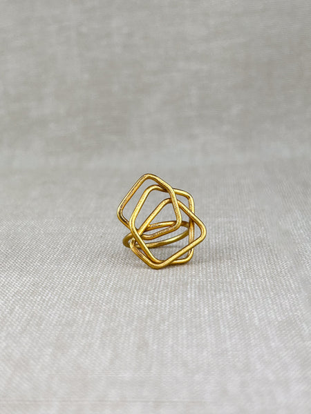 Ein moderner Ring mit klarer, architektonischer Formensprache. Handgefertigt aus feinem 100% recyceltem Sterlingsilber 925, besticht dieses Schmuckstück durch seine leichte, offene Struktur aus ineinander verschlungenen Quadraten. Die matte Oberfläche verleiht dem Ring eine sanfte, elegante Ausstrahlung – zeitlos und doch auffällig.