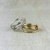 Ein Ring voller Bewegung und Leichtigkeit. Dieses außergewöhnliche Design aus 100% recyceltem Silber 925 oder 100% recyceltem 14 Karat Gold spielt mit fließenden, sich kreuzenden Linien, die an ein Hula Hoop in Bewegung erinnern. Die glänzende Oberfläche reflektiert das Licht sanft und betont die dynamische Form – ein Schmuckstück, das gleichzeitig modern und klassisch wirkt.